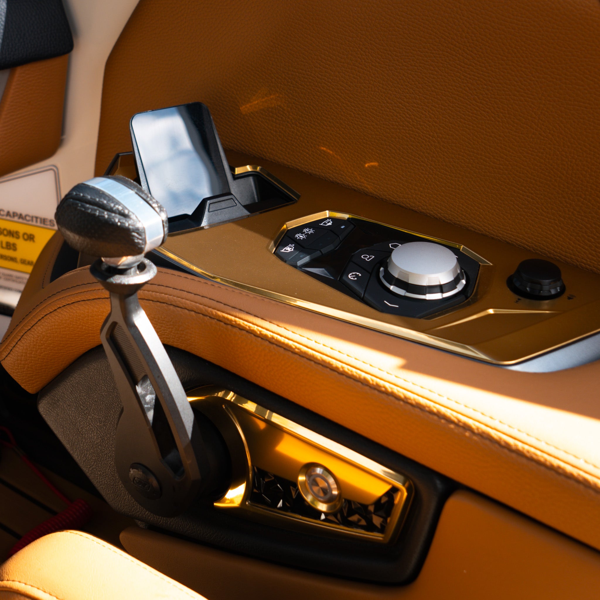 Close-up of a gold-trimmed Heliarc boat control panel featuring a rotary dial, toggle switches, and lever, freshly detailed by Pure Power Detailing