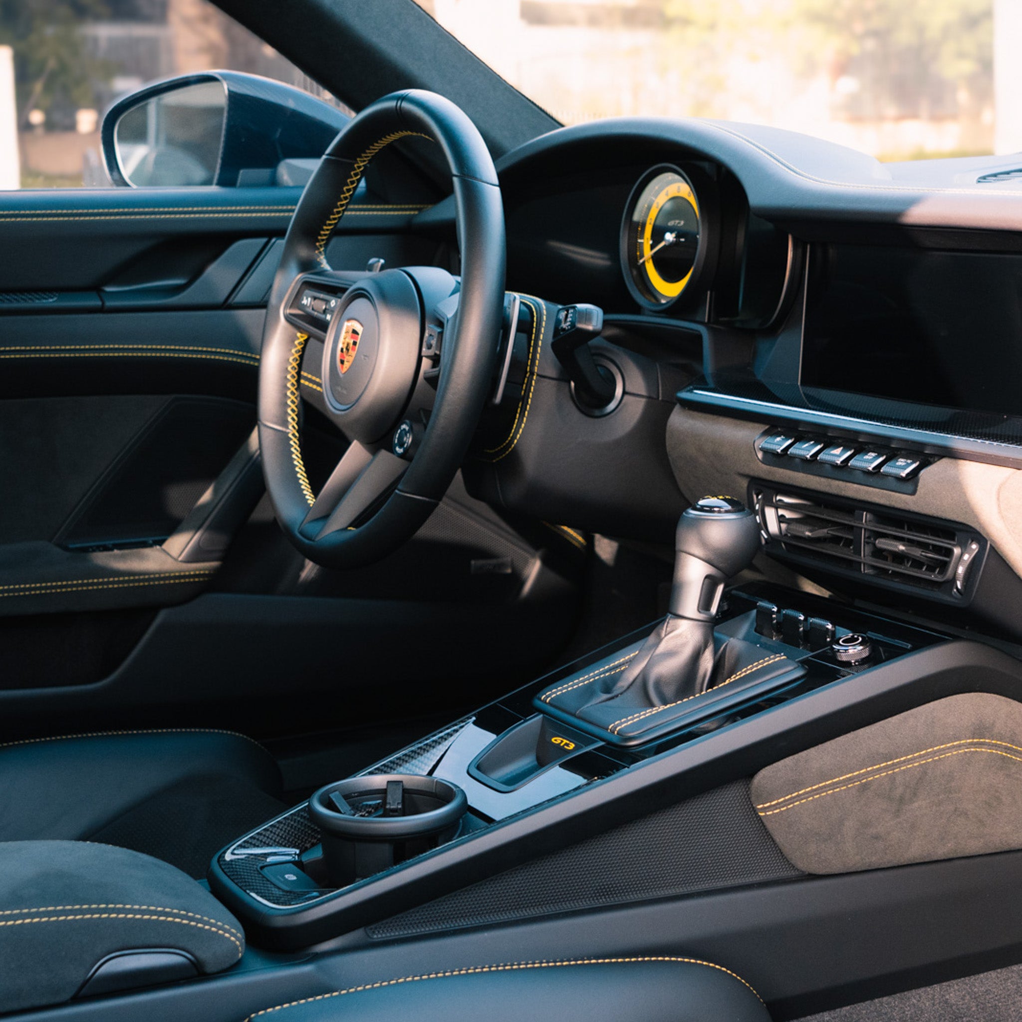Close-up of a Porsche GT3 interior featuring yellow stitching, leather, and Alcantara surfaces after a luxury interior detailing service by Pure Power